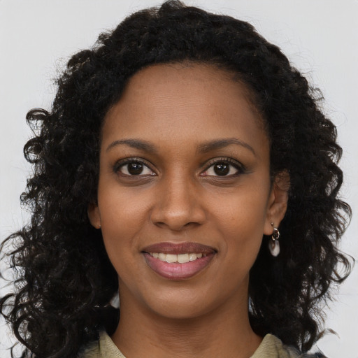 Joyful black young-adult female with long  brown hair and brown eyes