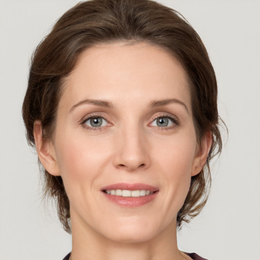 Joyful white young-adult female with medium  brown hair and grey eyes