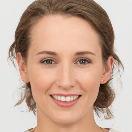 Joyful white young-adult female with medium  brown hair and grey eyes