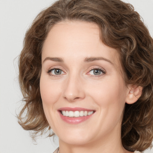 Joyful white young-adult female with medium  brown hair and green eyes