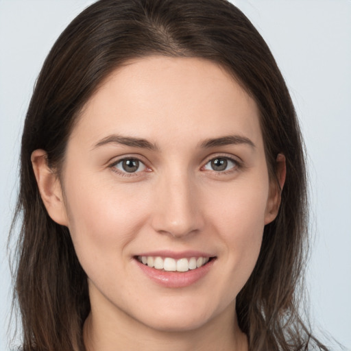 Joyful white young-adult female with long  brown hair and grey eyes