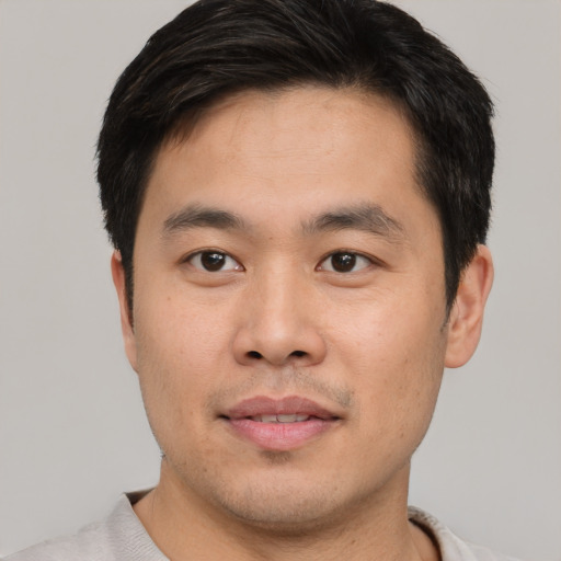 Joyful asian young-adult male with short  black hair and brown eyes
