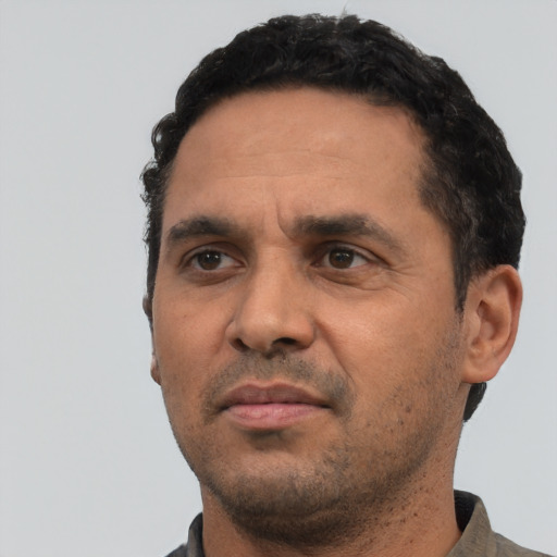 Neutral latino adult male with short  black hair and brown eyes