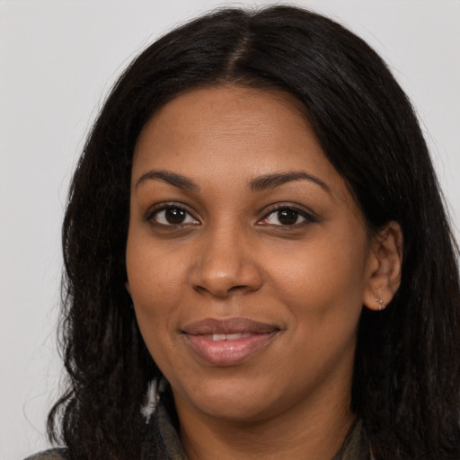 Joyful black young-adult female with long  brown hair and brown eyes