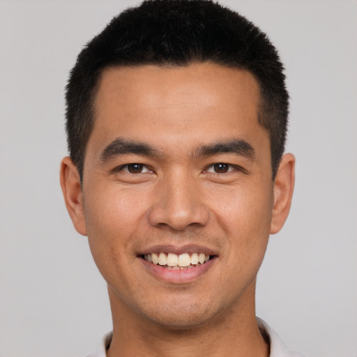 Joyful asian young-adult male with short  black hair and brown eyes