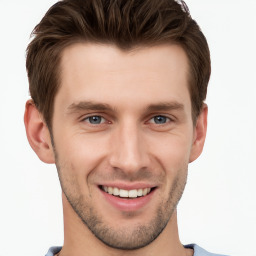 Joyful white young-adult male with short  brown hair and grey eyes