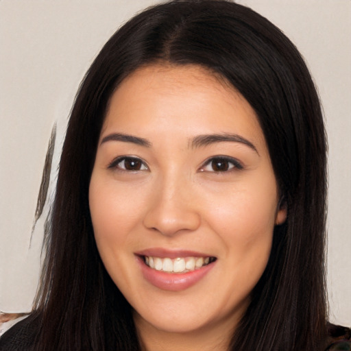 Joyful latino young-adult female with long  brown hair and brown eyes