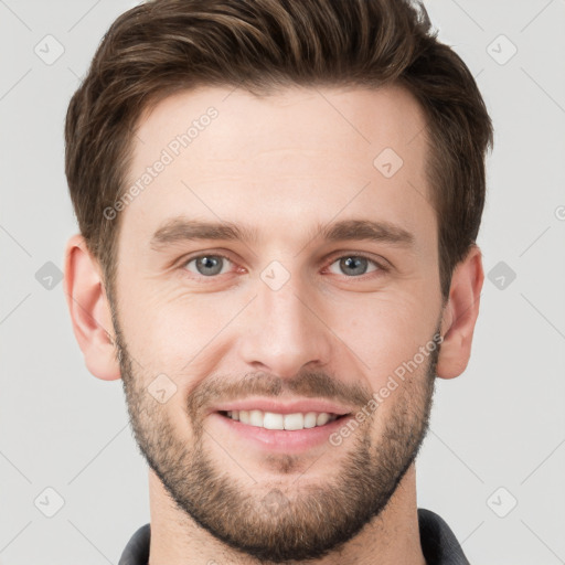 Joyful white young-adult male with short  brown hair and grey eyes