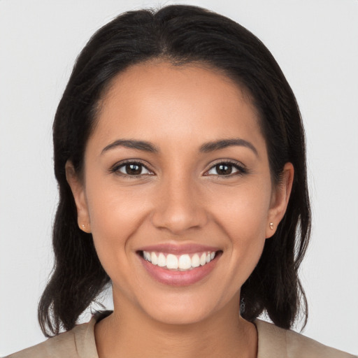 Joyful latino young-adult female with long  brown hair and brown eyes