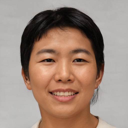 Joyful asian young-adult female with short  black hair and brown eyes