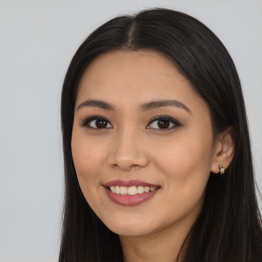 Joyful latino young-adult female with long  black hair and brown eyes