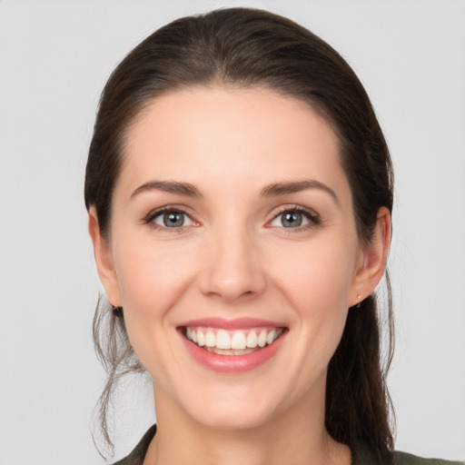 Joyful white young-adult female with medium  brown hair and grey eyes