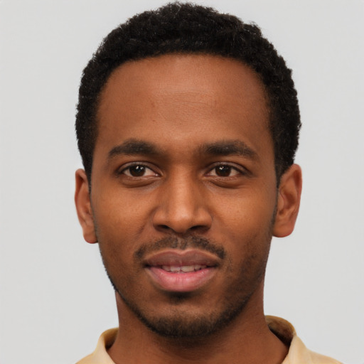 Joyful black young-adult male with short  black hair and brown eyes