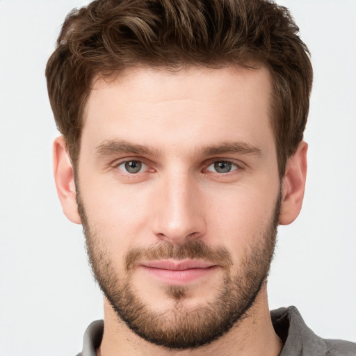 Joyful white young-adult male with short  brown hair and grey eyes