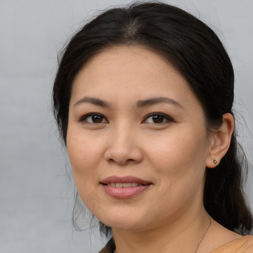 Joyful asian adult female with medium  brown hair and brown eyes
