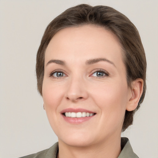 Joyful white young-adult female with medium  brown hair and green eyes