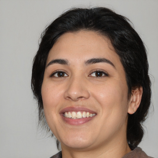Joyful latino young-adult female with medium  black hair and brown eyes