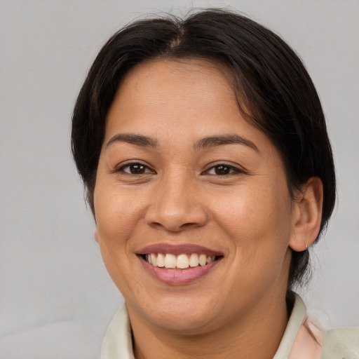 Joyful asian adult female with medium  brown hair and brown eyes