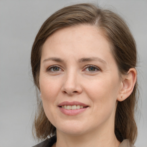 Joyful white young-adult female with medium  brown hair and grey eyes