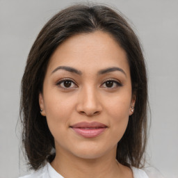 Joyful latino young-adult female with medium  brown hair and brown eyes