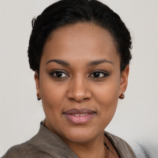 Joyful black young-adult female with short  black hair and brown eyes