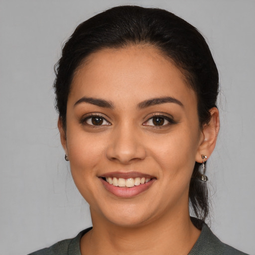 Joyful latino young-adult female with medium  brown hair and brown eyes