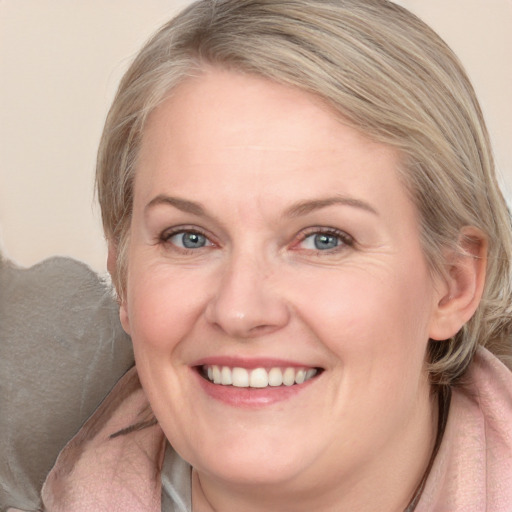 Joyful white adult female with medium  brown hair and blue eyes