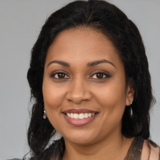 Joyful black young-adult female with long  brown hair and brown eyes