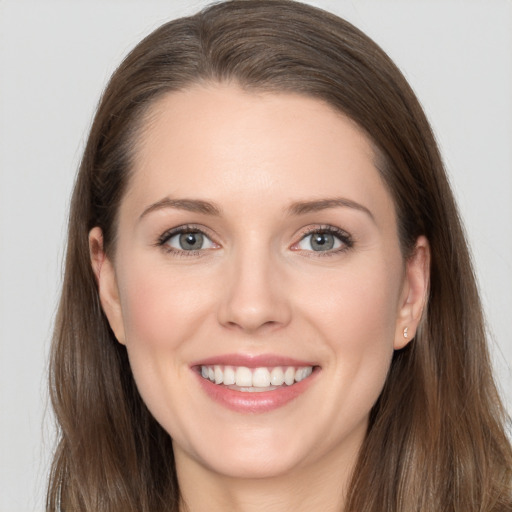 Joyful white young-adult female with long  brown hair and grey eyes