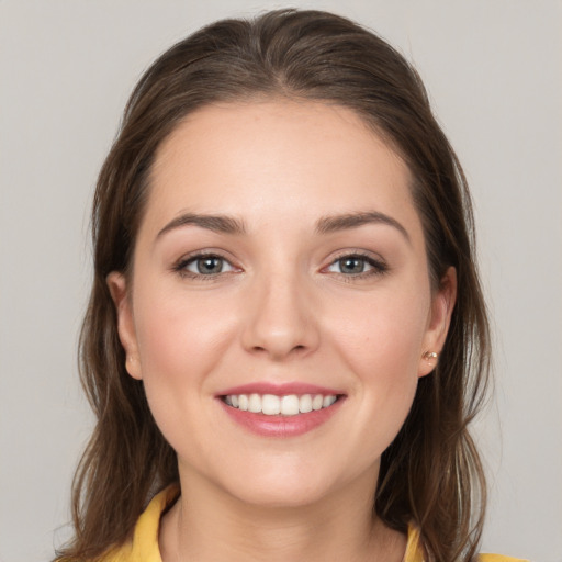 Joyful white young-adult female with long  brown hair and brown eyes