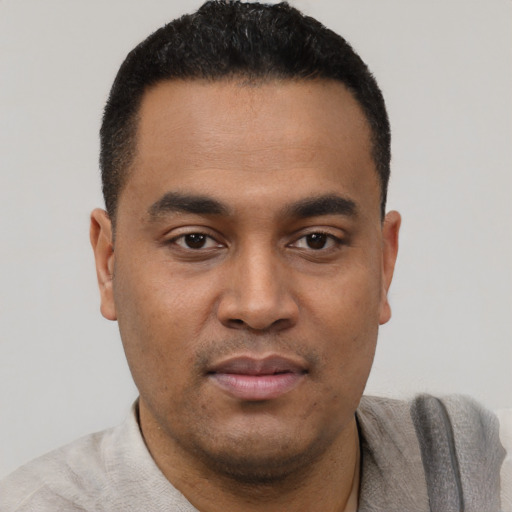 Joyful latino young-adult male with short  black hair and brown eyes