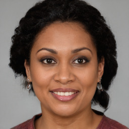 Joyful black adult female with medium  brown hair and brown eyes