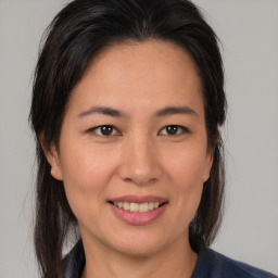 Joyful asian young-adult female with medium  brown hair and brown eyes