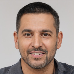 Joyful white adult male with short  black hair and brown eyes