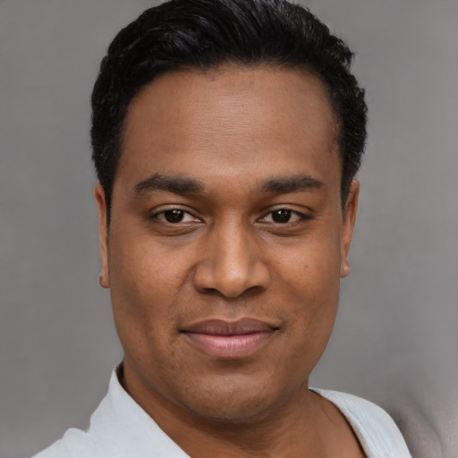 Joyful latino young-adult male with short  black hair and brown eyes