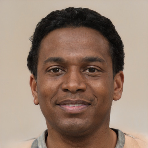 Joyful black young-adult male with short  black hair and brown eyes