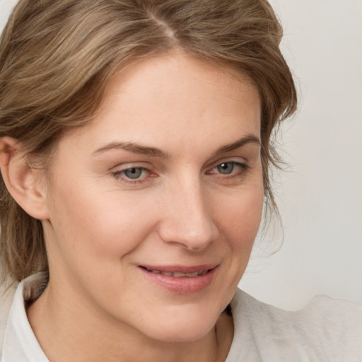 Joyful white young-adult female with medium  brown hair and blue eyes