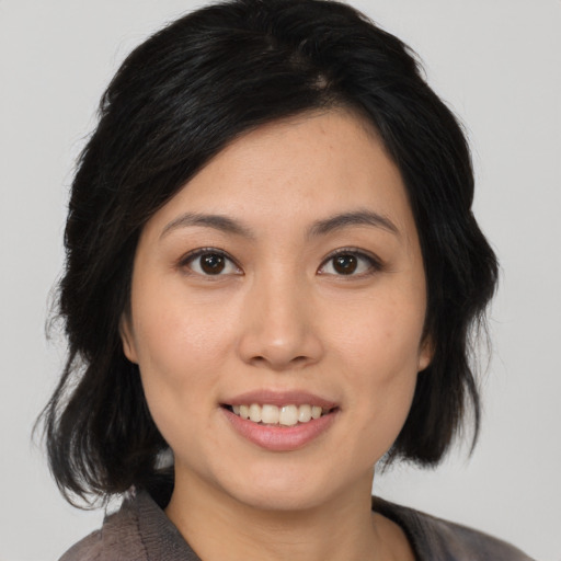 Joyful asian young-adult female with medium  black hair and brown eyes