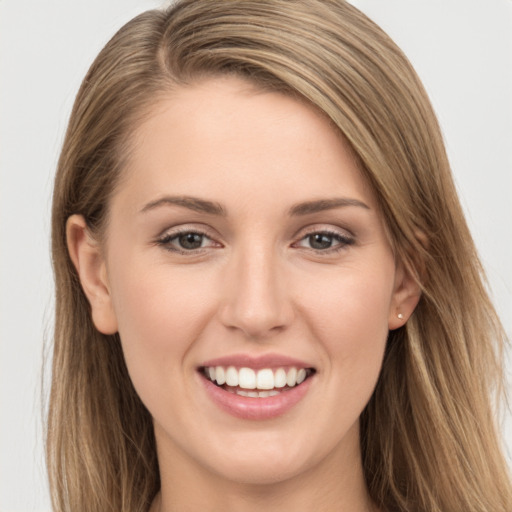 Joyful white young-adult female with long  brown hair and grey eyes