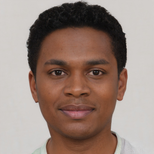 Joyful black young-adult male with short  brown hair and brown eyes