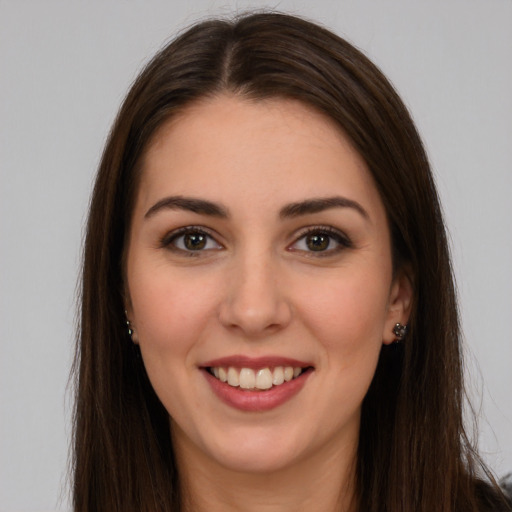 Joyful white young-adult female with long  brown hair and brown eyes