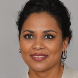 Joyful black adult female with medium  brown hair and brown eyes