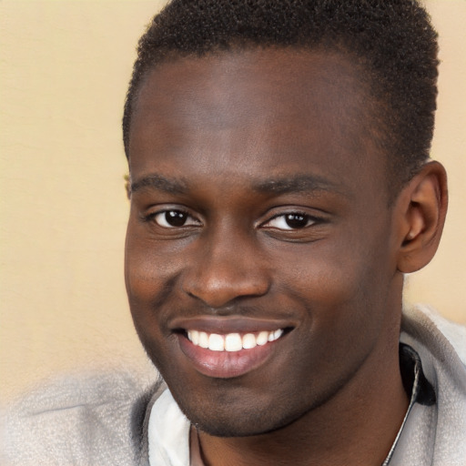 Joyful black young-adult male with short  brown hair and brown eyes