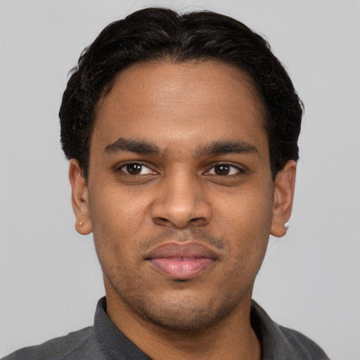 Joyful black young-adult male with short  black hair and brown eyes
