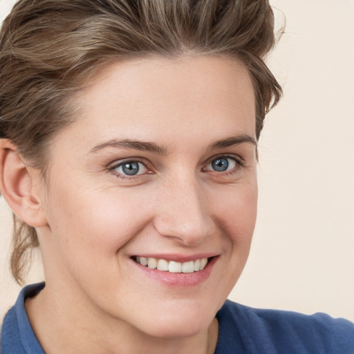 Joyful white young-adult female with short  brown hair and blue eyes