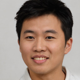 Joyful asian young-adult male with short  brown hair and brown eyes