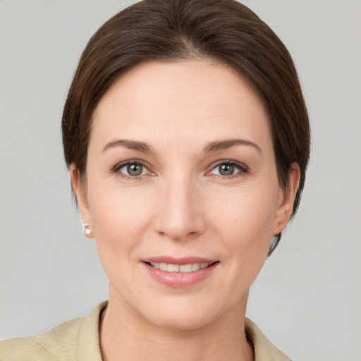 Joyful white young-adult female with short  brown hair and grey eyes