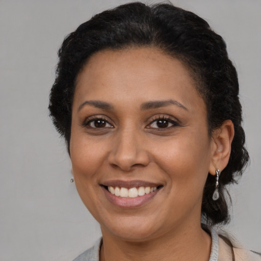 Joyful latino adult female with short  brown hair and brown eyes