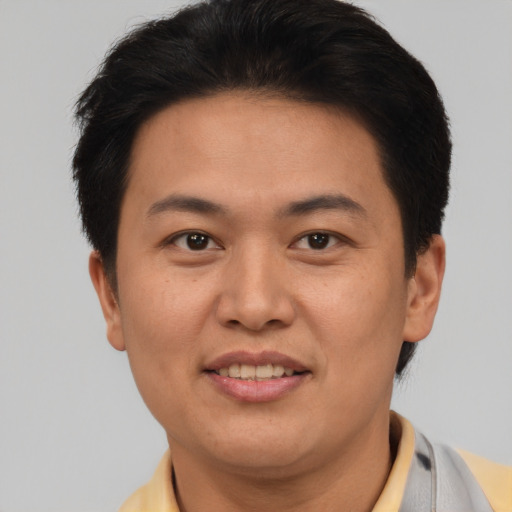Joyful asian adult male with short  brown hair and brown eyes