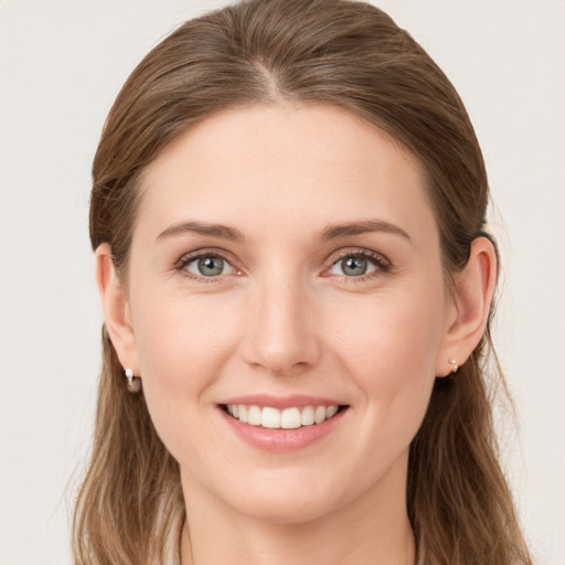 Joyful white young-adult female with long  brown hair and blue eyes